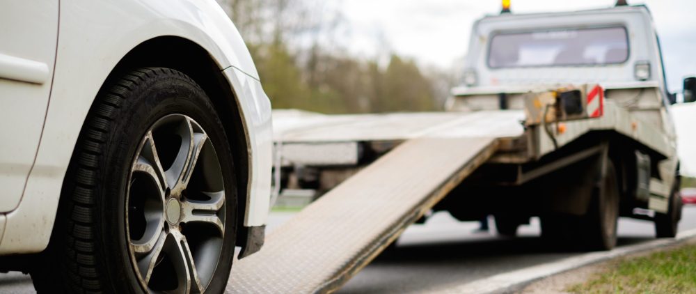 Loading broken car on a tow truck on a roadside